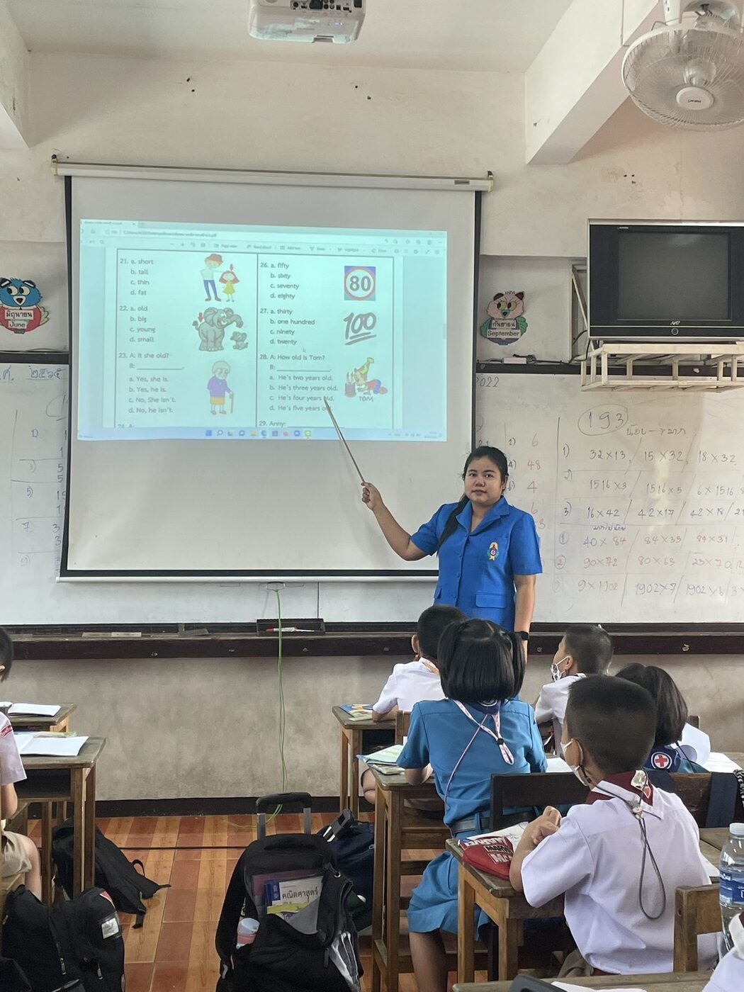 ครูลภัสร์ลดา พรมสอน ทบทวนข้อสอบภาษาอังกฤษบนจอโปรเจกเตอร์หน้าชั้นเรียน